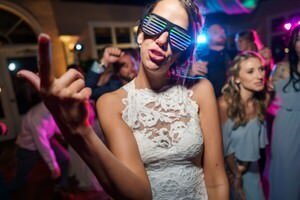 Bride wearing fun LED glasses dancing at wedding reception captured by professional St Augustine wedding photographer in Florida