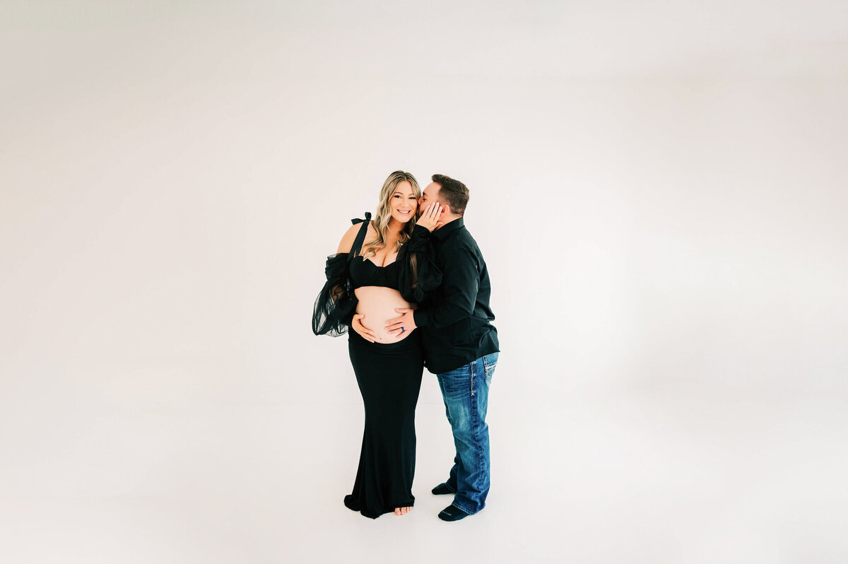 husband kissing pregnant mom on cheek during Springfield MO maternity photography session