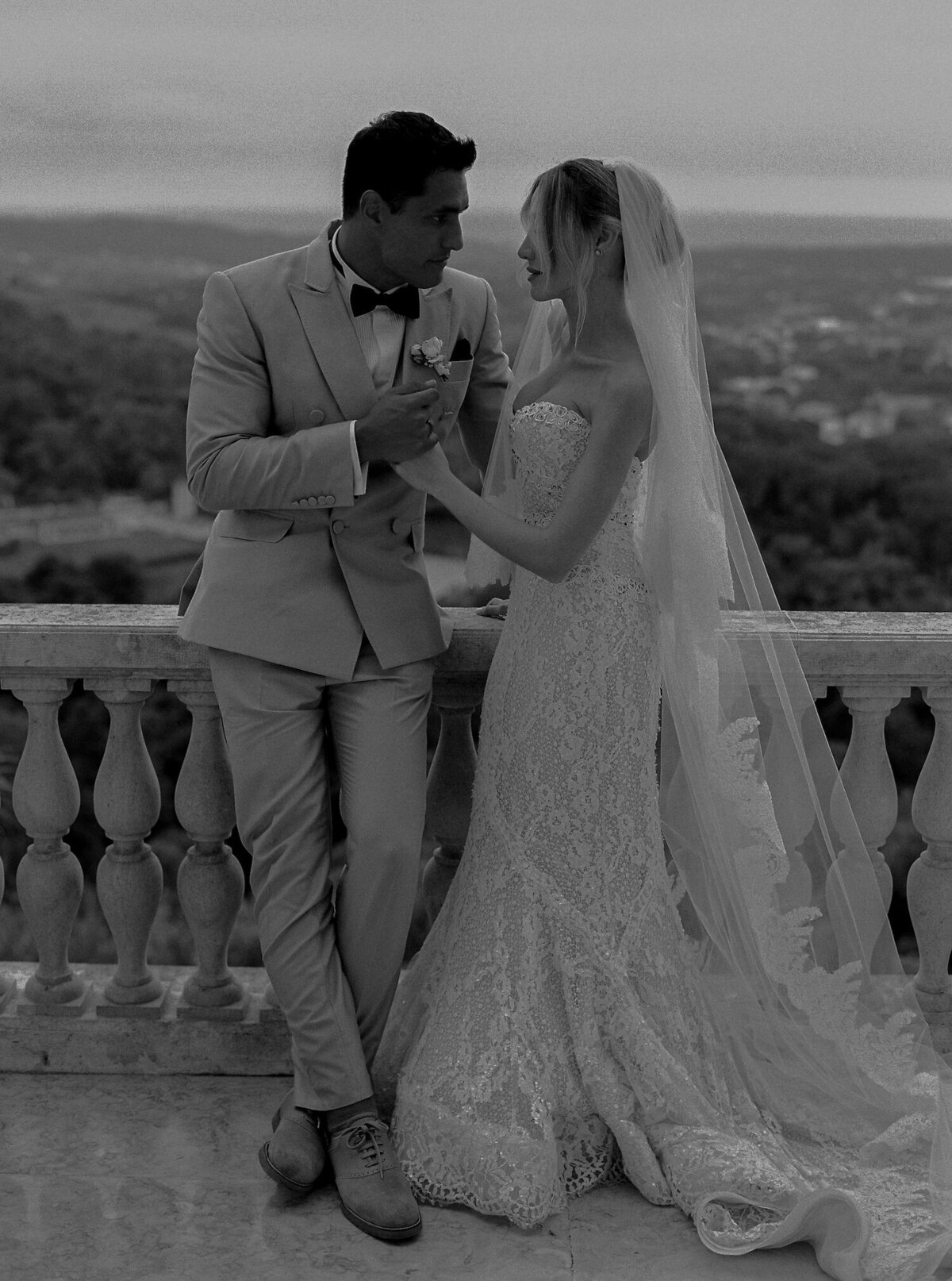 A black and white destination wedding photo of a couple relaxing after their ceremony in Quinta da Bellavista balcony