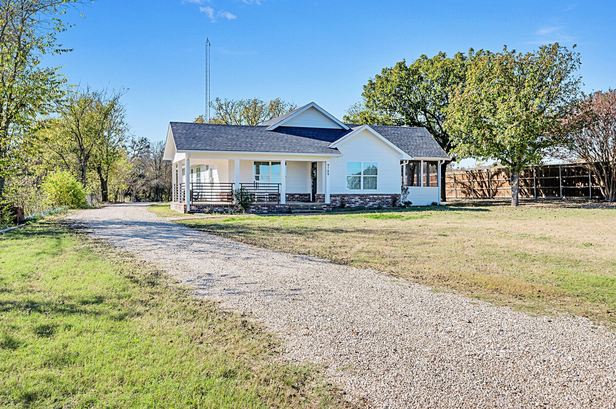 Exterior and yard of this four-bedroom, three-bathroom vacation rental home with game room, spa, and firepit located on the edge of Waco, TX.