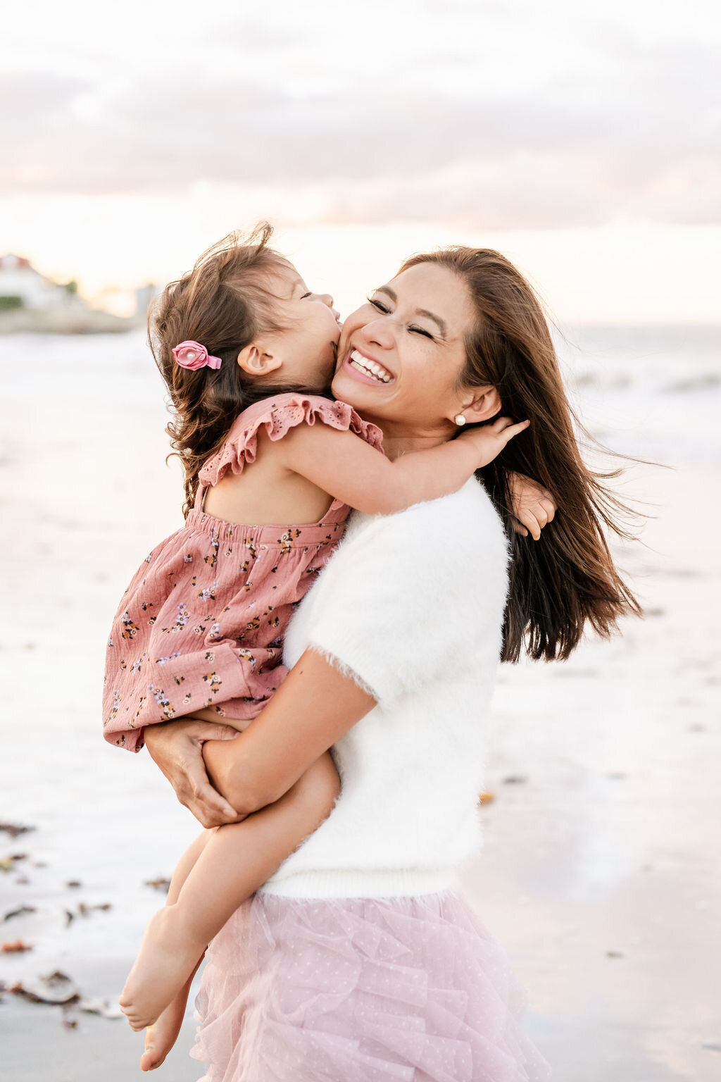 Mom and daughter laughing on the beach