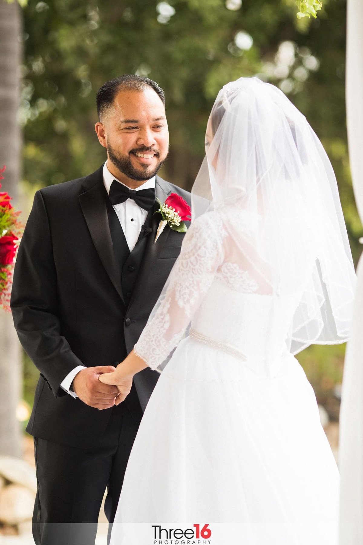 Groom smiles at his Bride while holding her hands