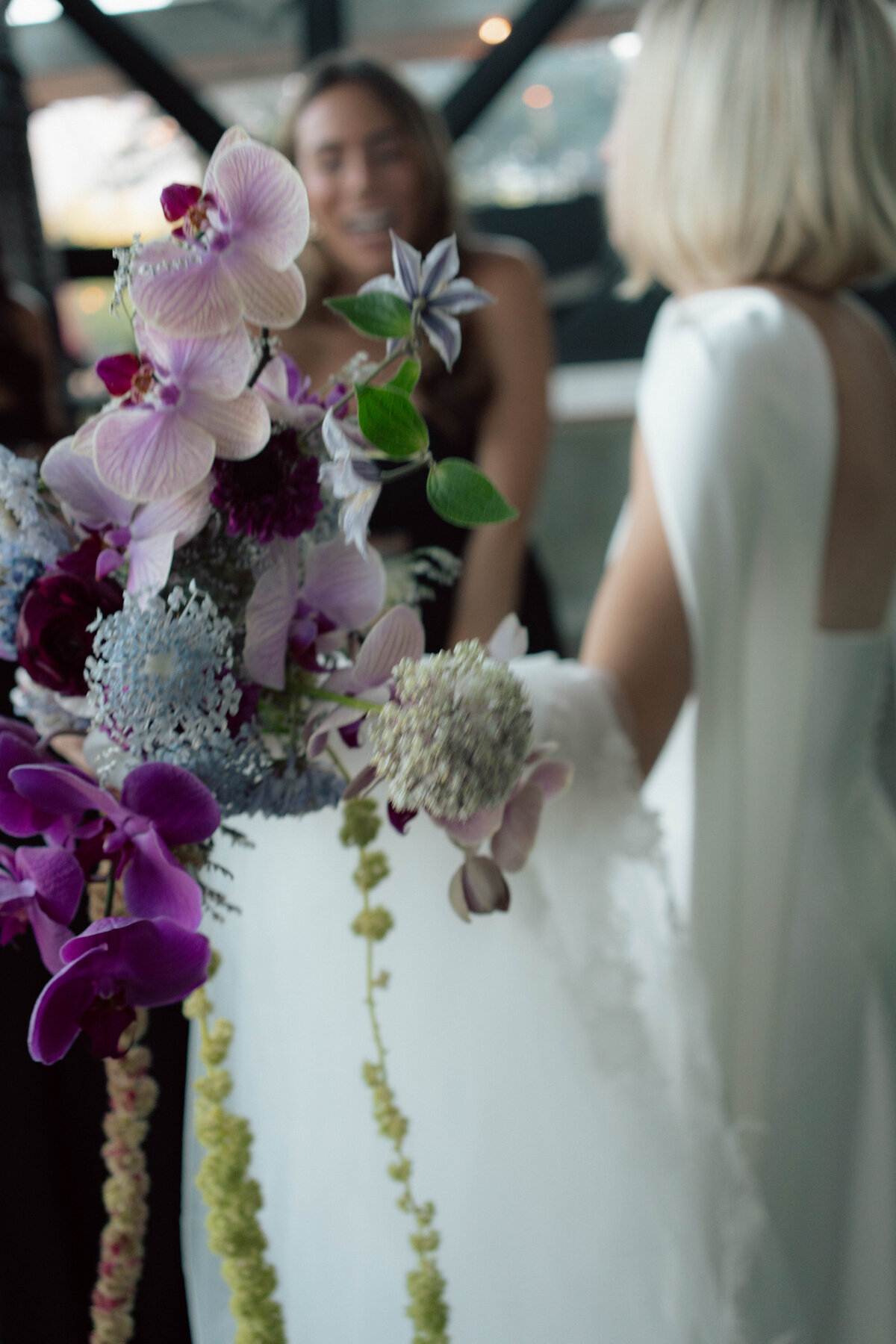 Close-up of wedding bouquet with orchids and textured florals in bride’s hand