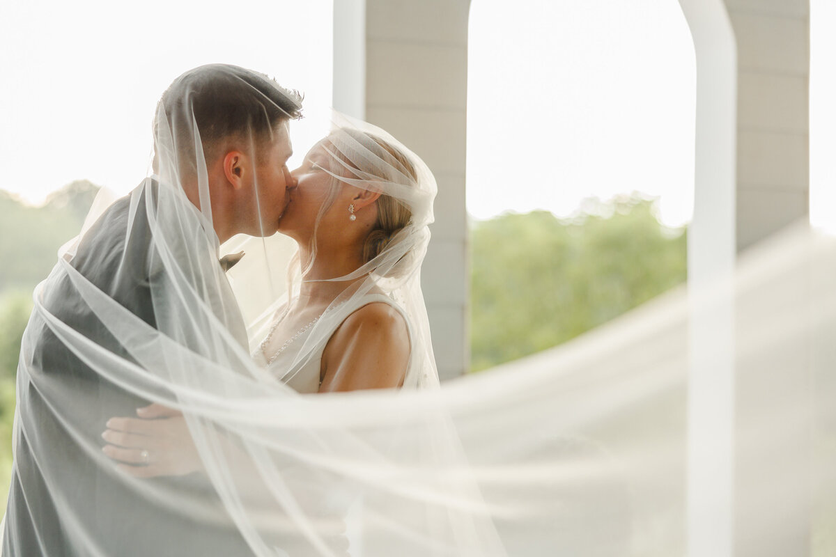 The bride and groom kissing under the veil.
