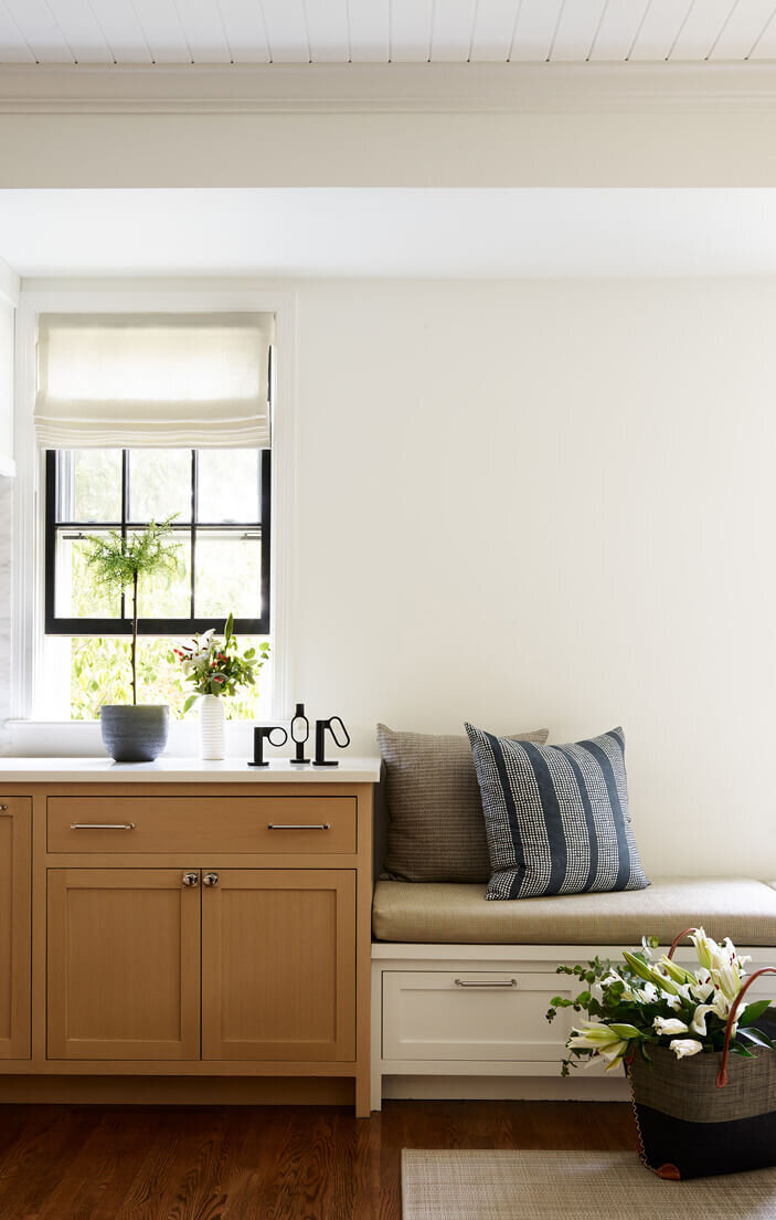 Natural oak cabinets and white built-ins at a kitchen renovation project in Hingham, designed by South Shore interior designers, blending warmth with modern elegance.