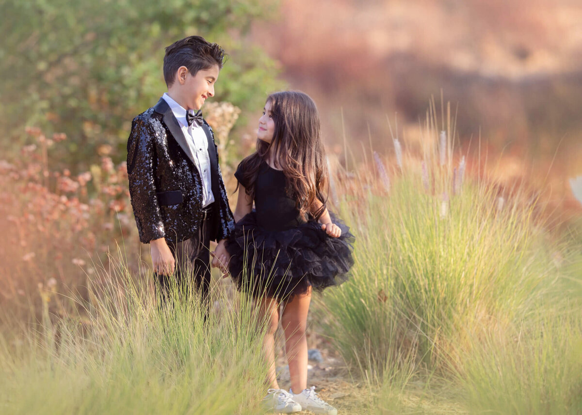 Brother and sister holding hands and looking at each other in the park in simi valley by Los Angeles children's photographer - Elsie Rose Photography