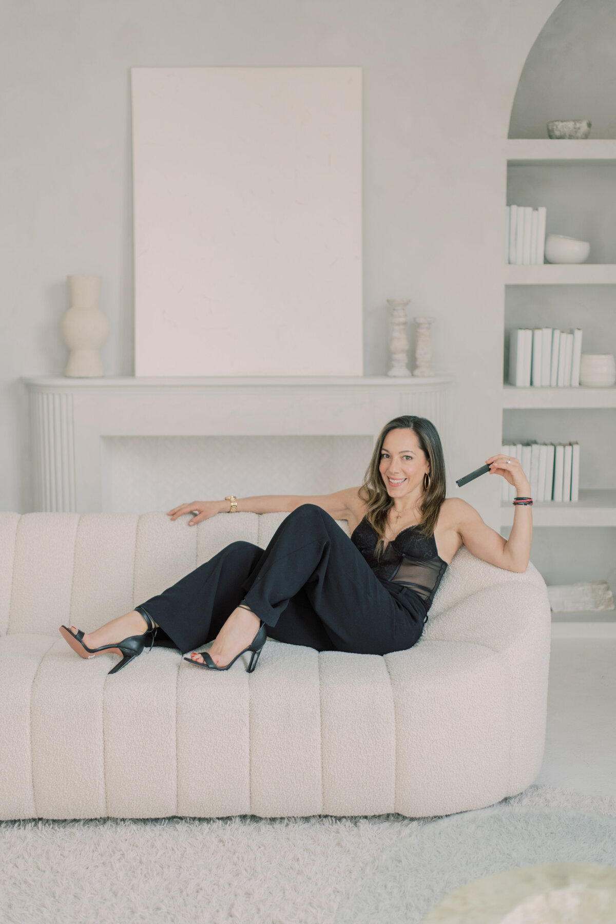 Chic detail of black high heels styled atop a minimalist ottoman.
