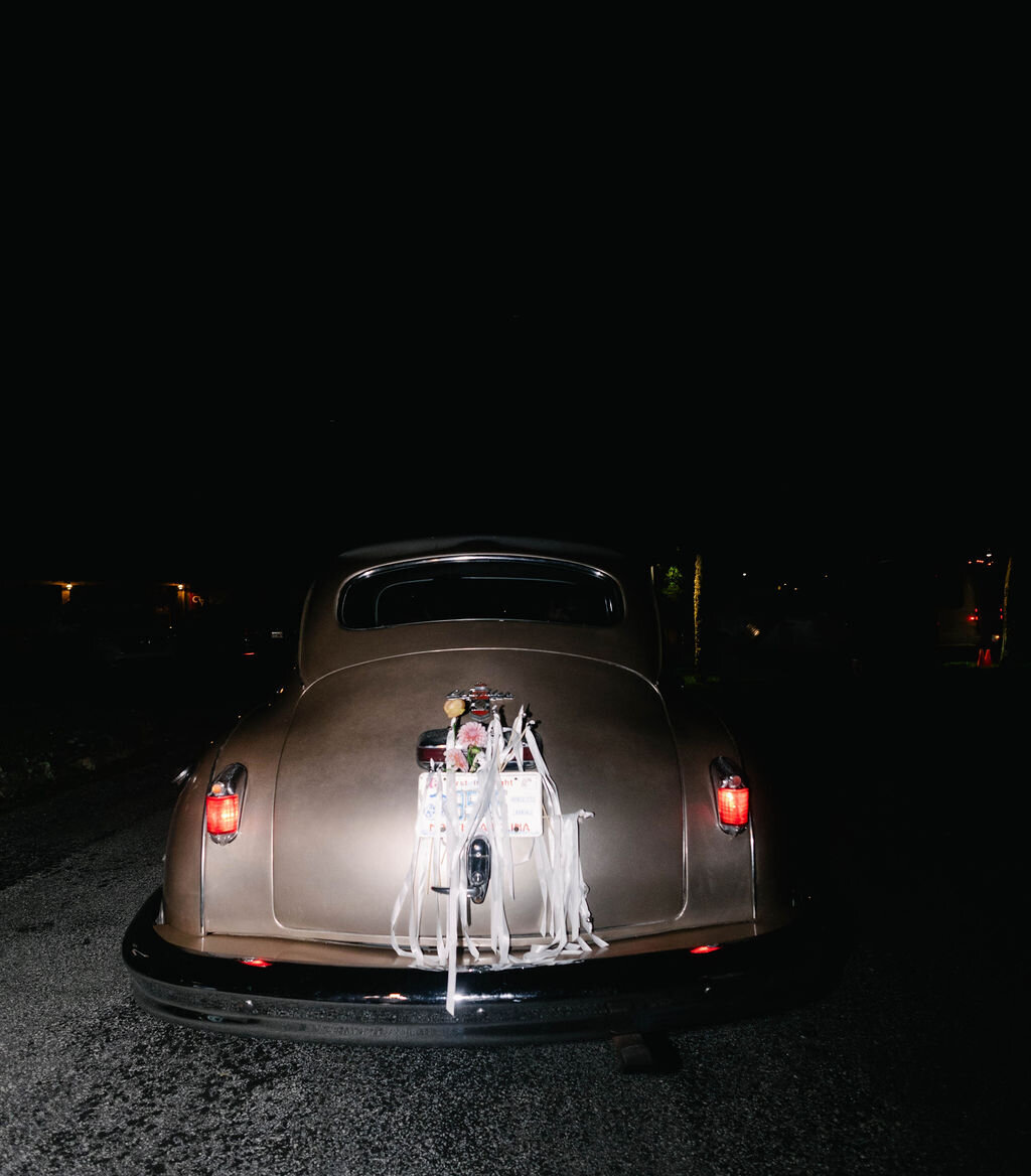 Rear view of the newlyweds’ vintage getaway car decorated for their Just Married exit after a wedding at The Bascom in Highlands, NC.