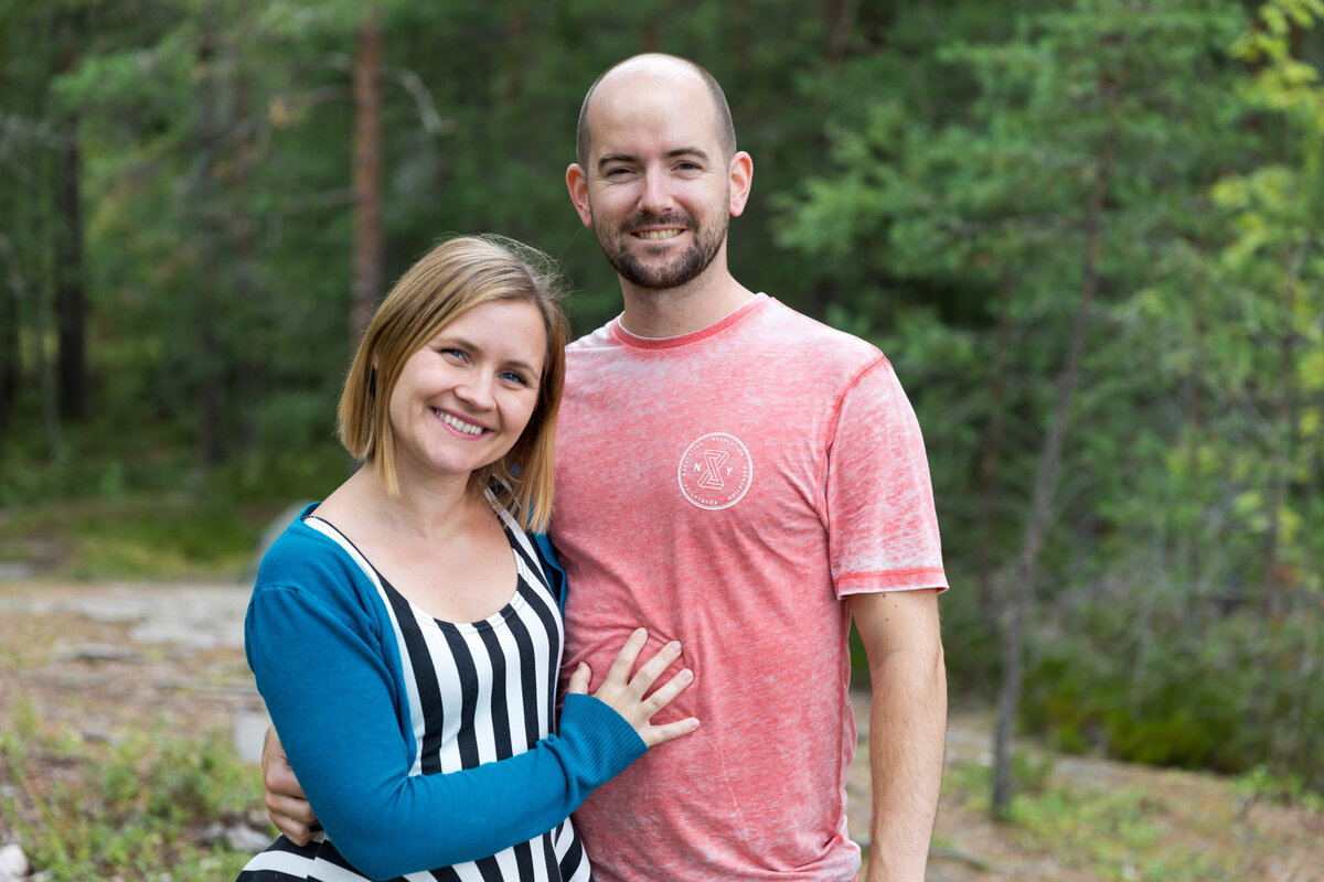 Livsstilsfoto portrett av et par som står vendt mot kamera og smiler.