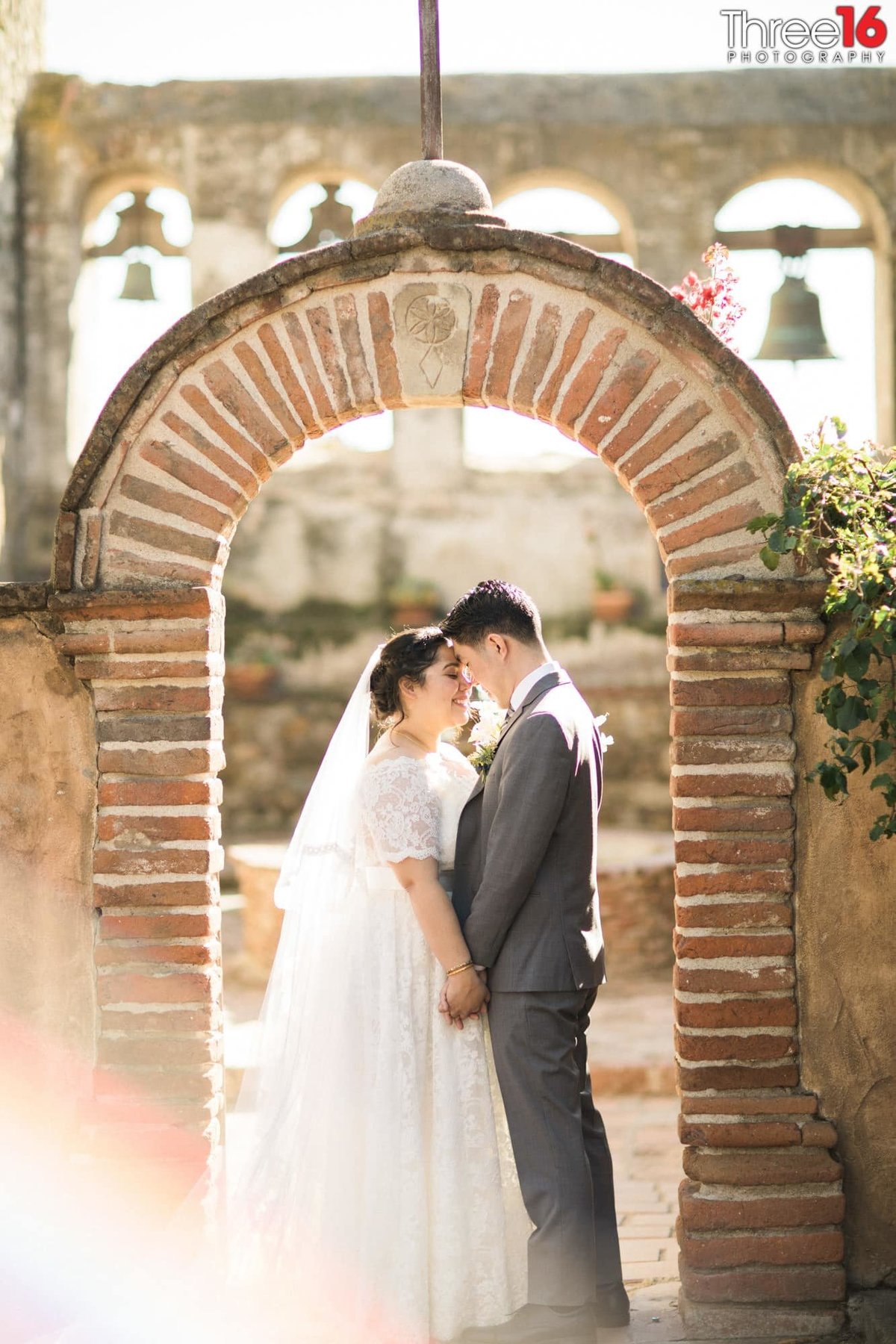 Tender moment for the Bride and Groom under the brick archway