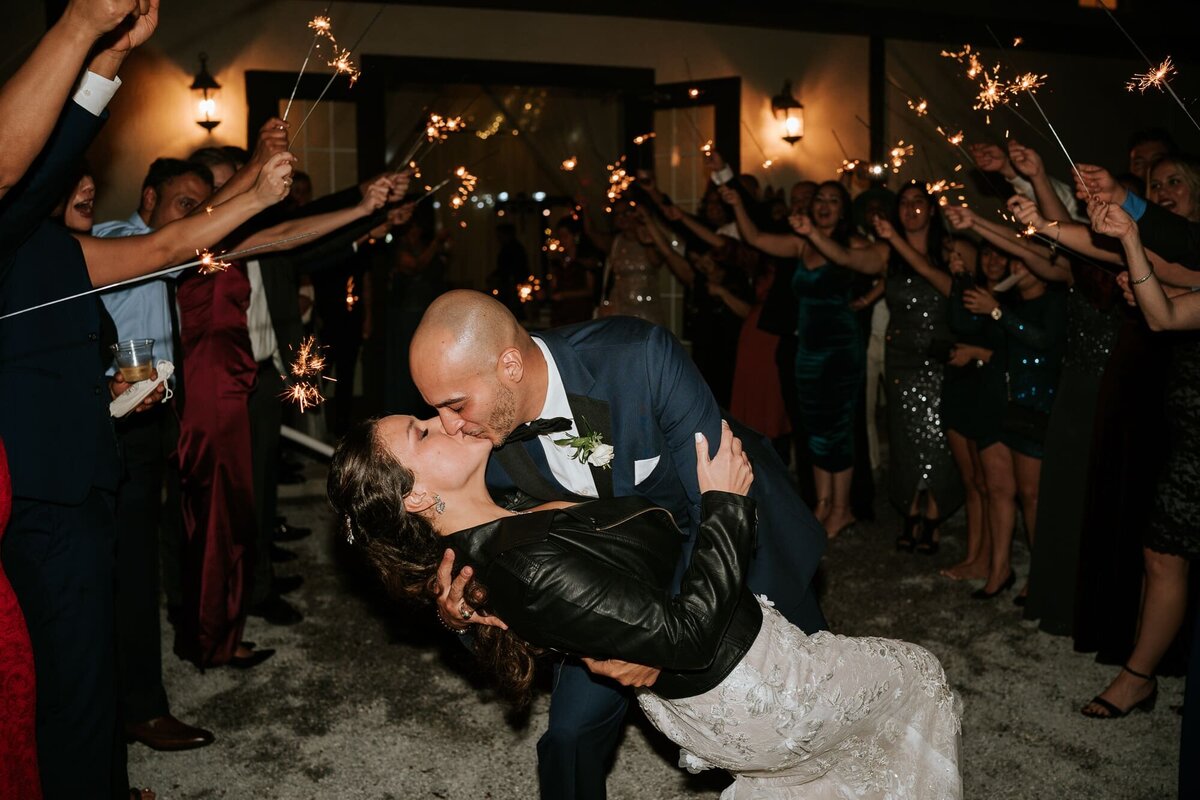 Groom dipping and kissing his bride during their send off at Bakers Ranch Tampa premier wedding venue