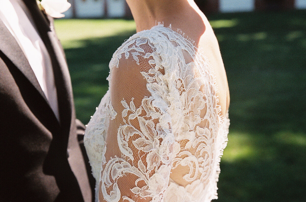 Close up of the lace on the brides dress. 