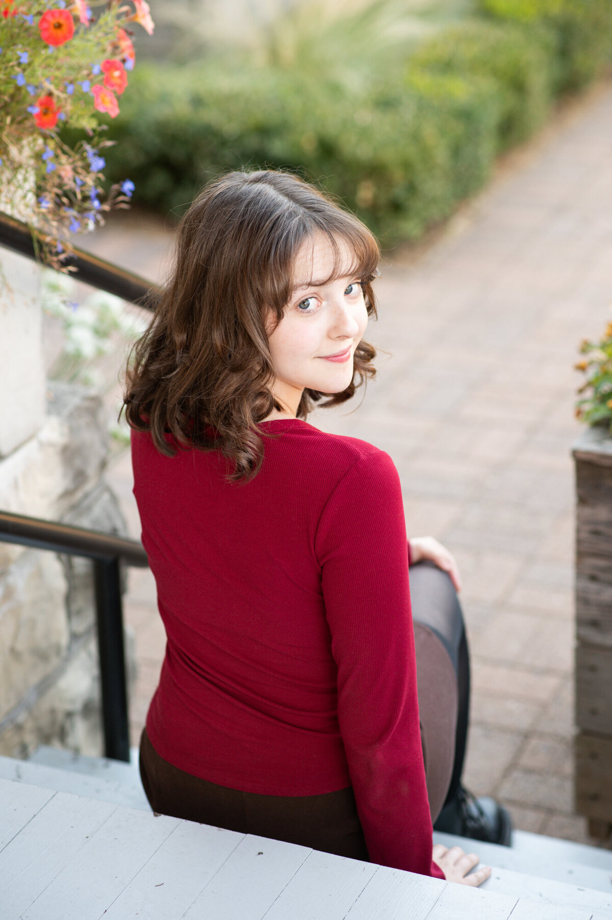 Image looking down the steps of a girl in a red shirt with brown hair.