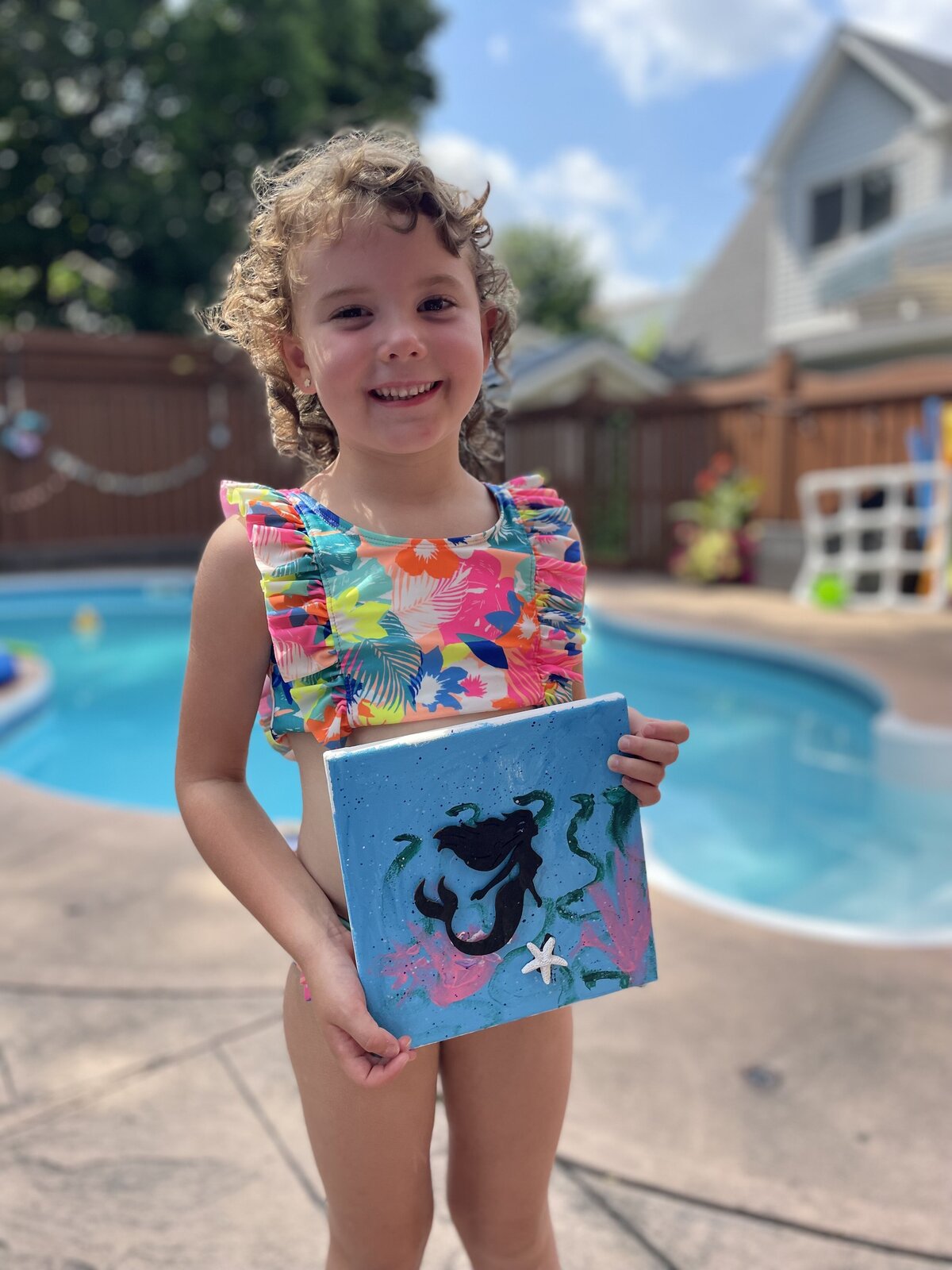 Happy child holding finished painting at a mobile kids’ paint party hosted by Young at Art in Durham Region