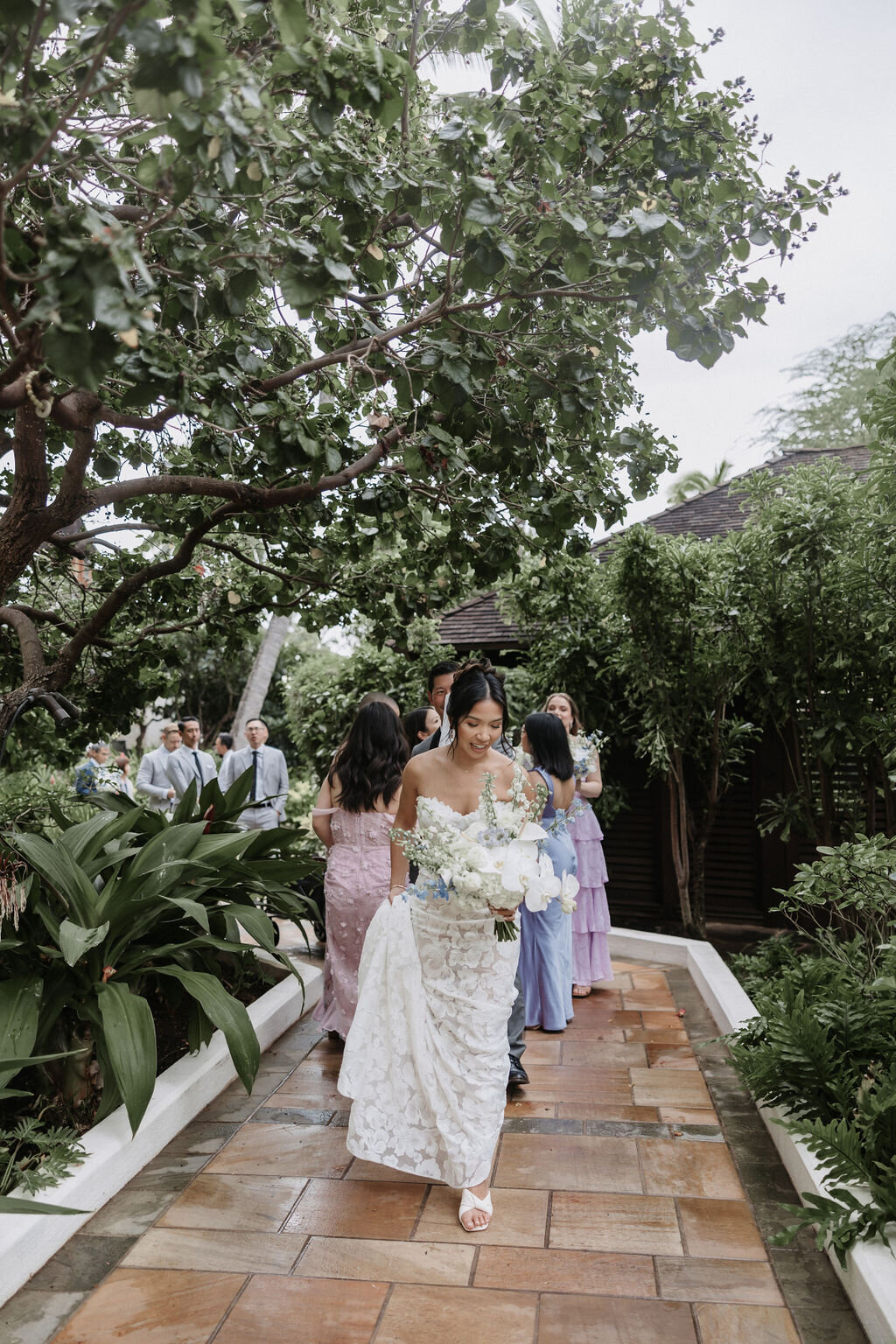 bride walking at four seasons with bridesmaids in multicolor dresses