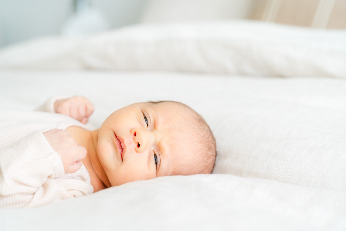 a newborn baby lays awake on his parents' bed at their Leander home. 
