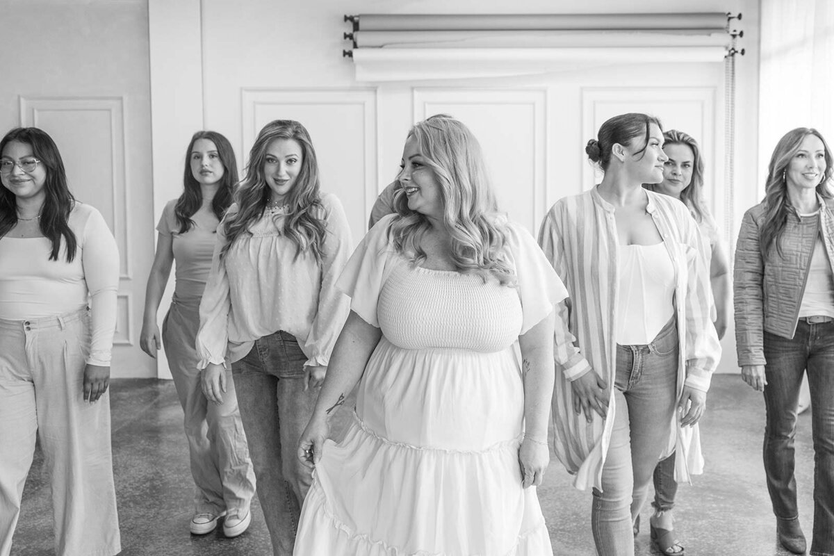 Group of hair and makeup stylists standing and siting together, smiling 
