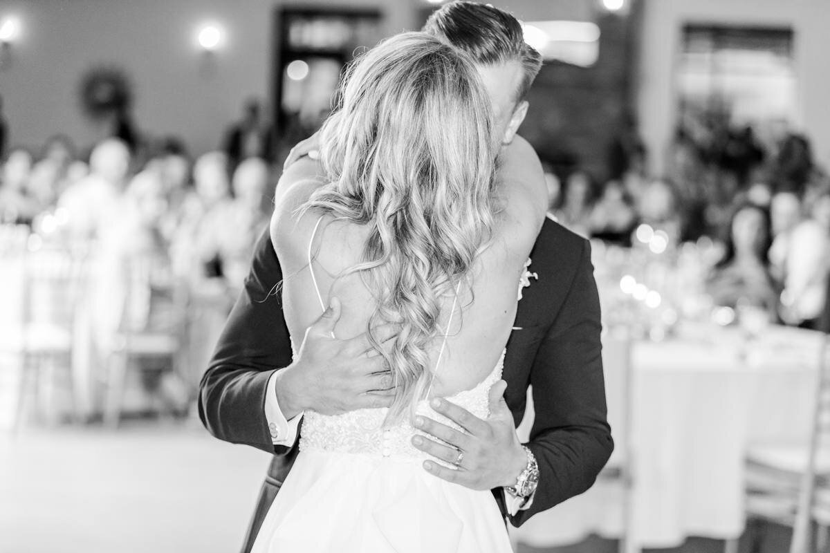black and white photo of bride and groom kissing during first dance