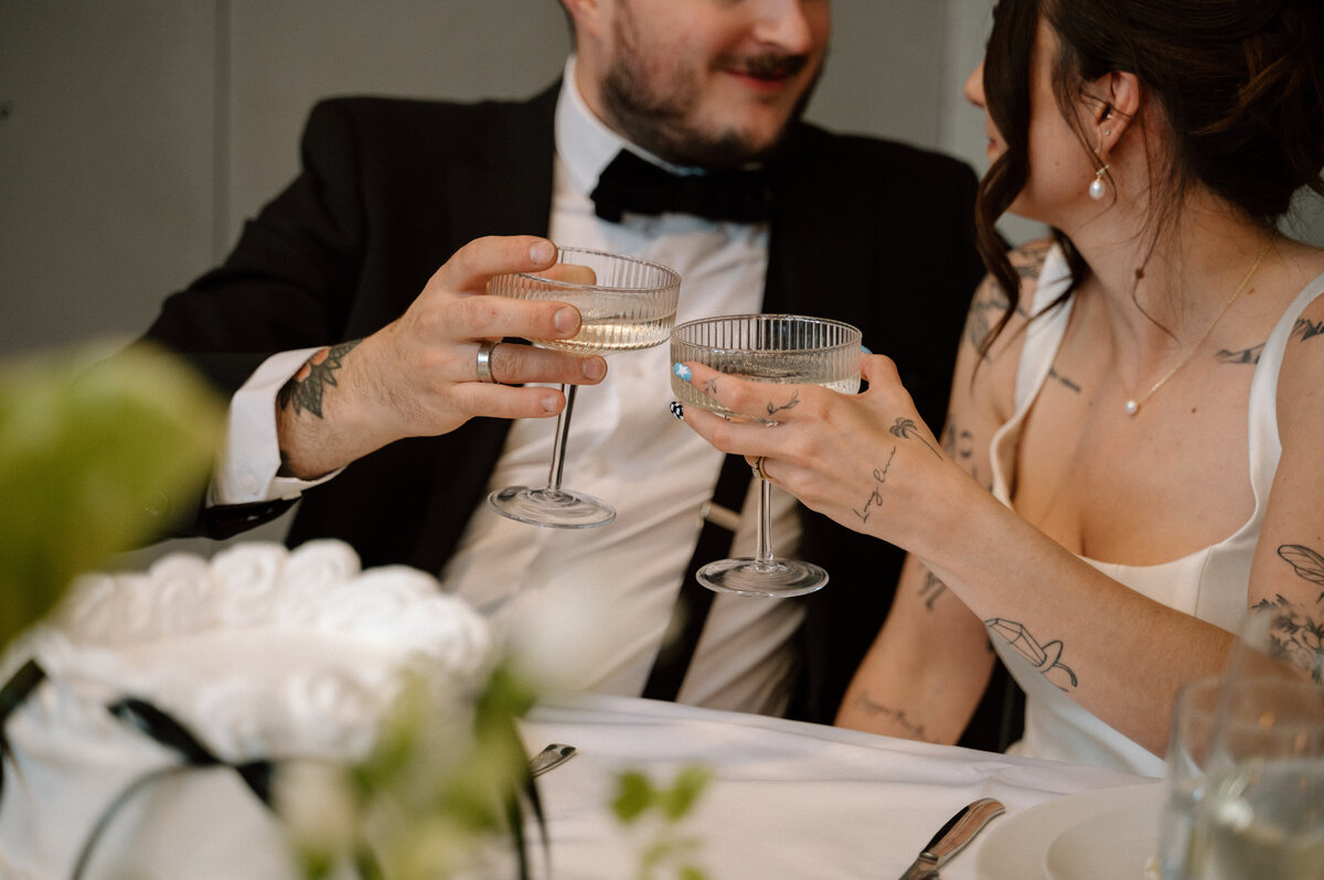 Close-up of bride and groom toasting with vintage glasses at Banff wedding.