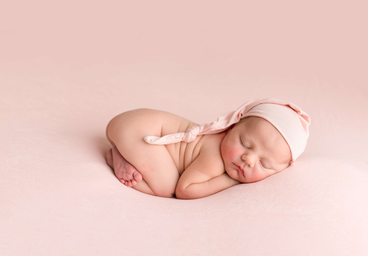 Infant in Woodinville Studio with pink bow wrapped in pink