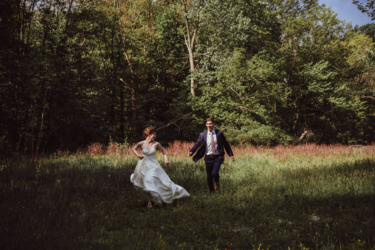 Couple runs through a field after getting eloped with Paige Mireles Photography