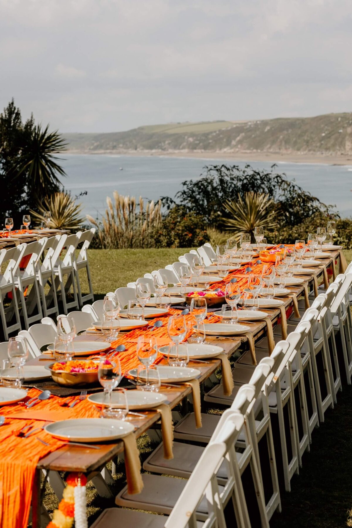 A long table set up with orange and white linens