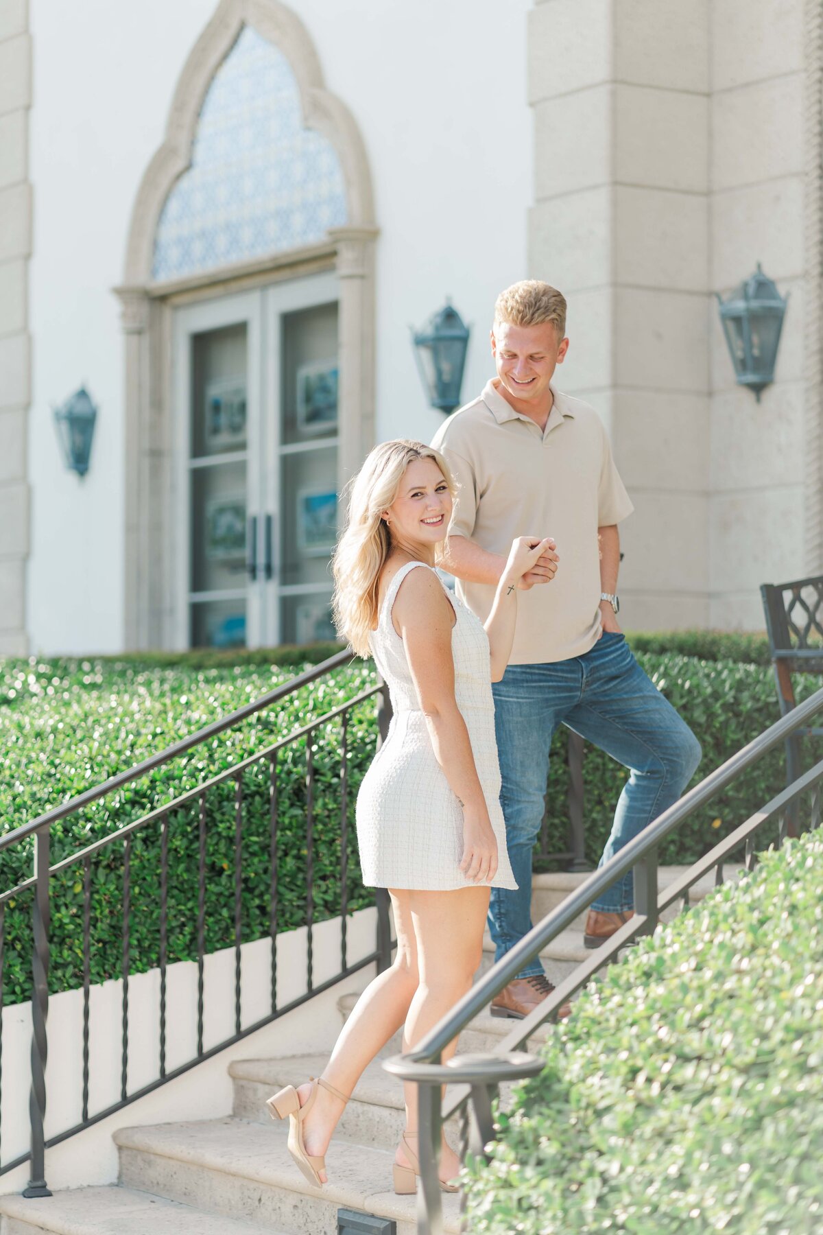 a couple holding hands walking while looking at each other and smiling
