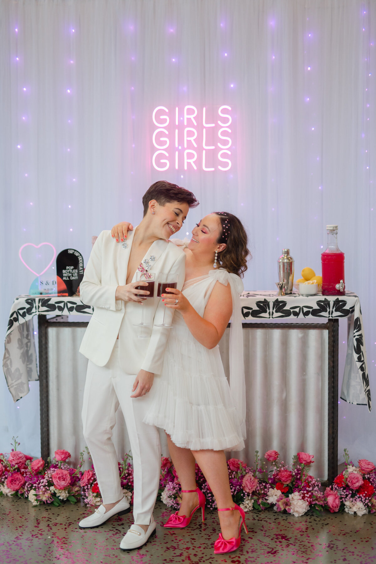 Two brides cheersing glasses at the wedding bar