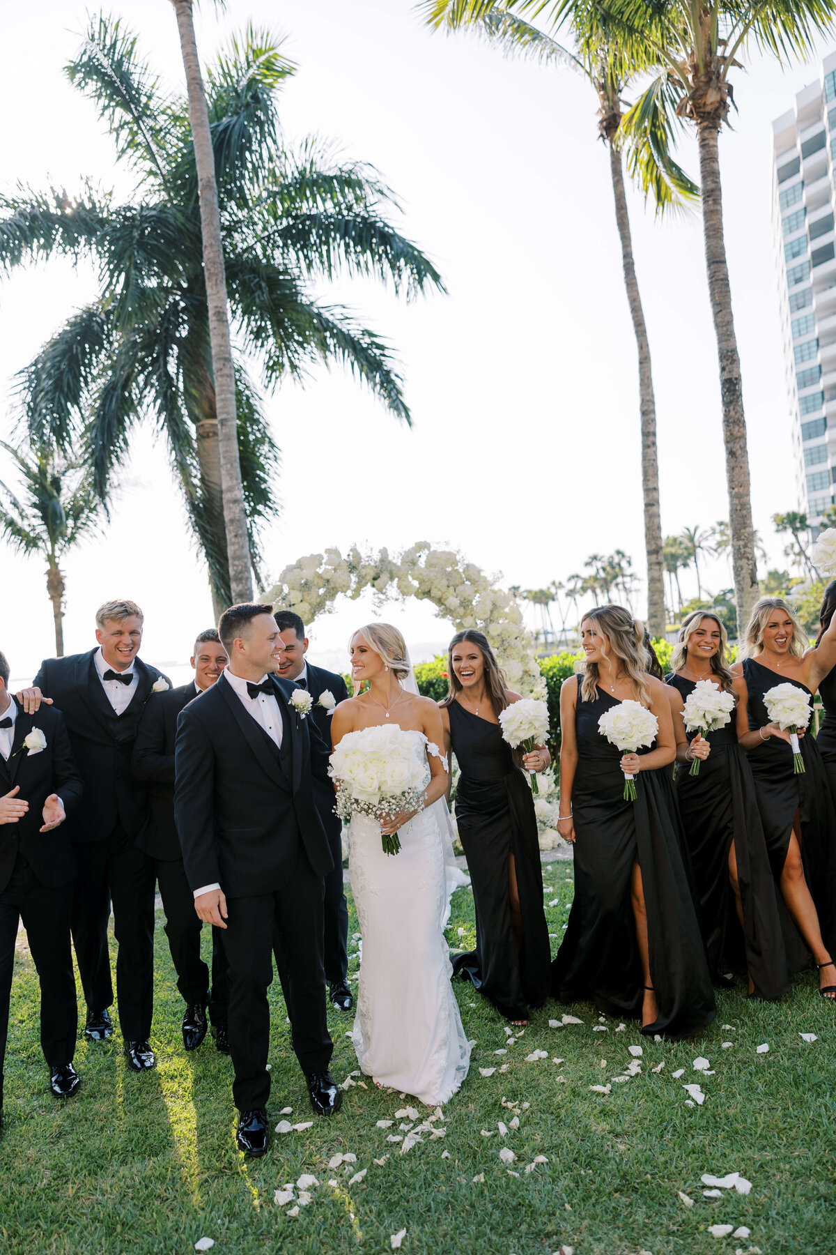 Bride and groom standing with their groomsmen and bridesmaids at outdoor wedding ceremony