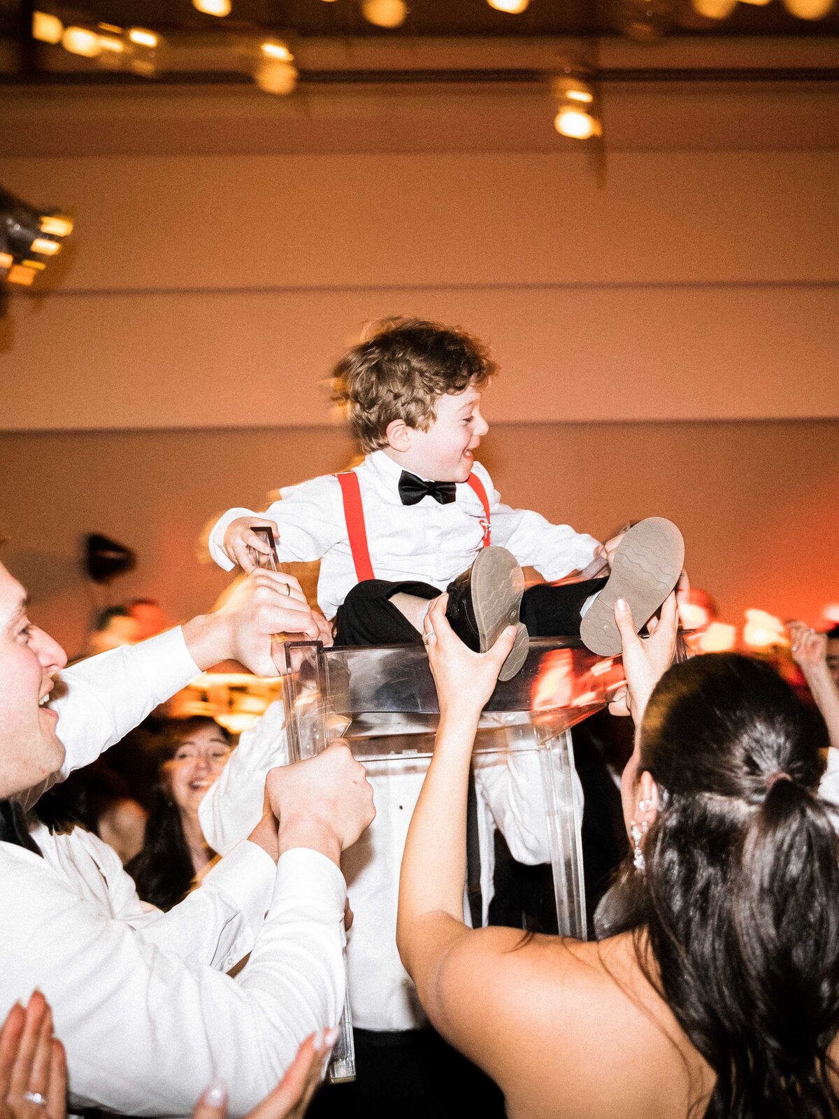 Child lifted on chair during wedding reception at park hyatt