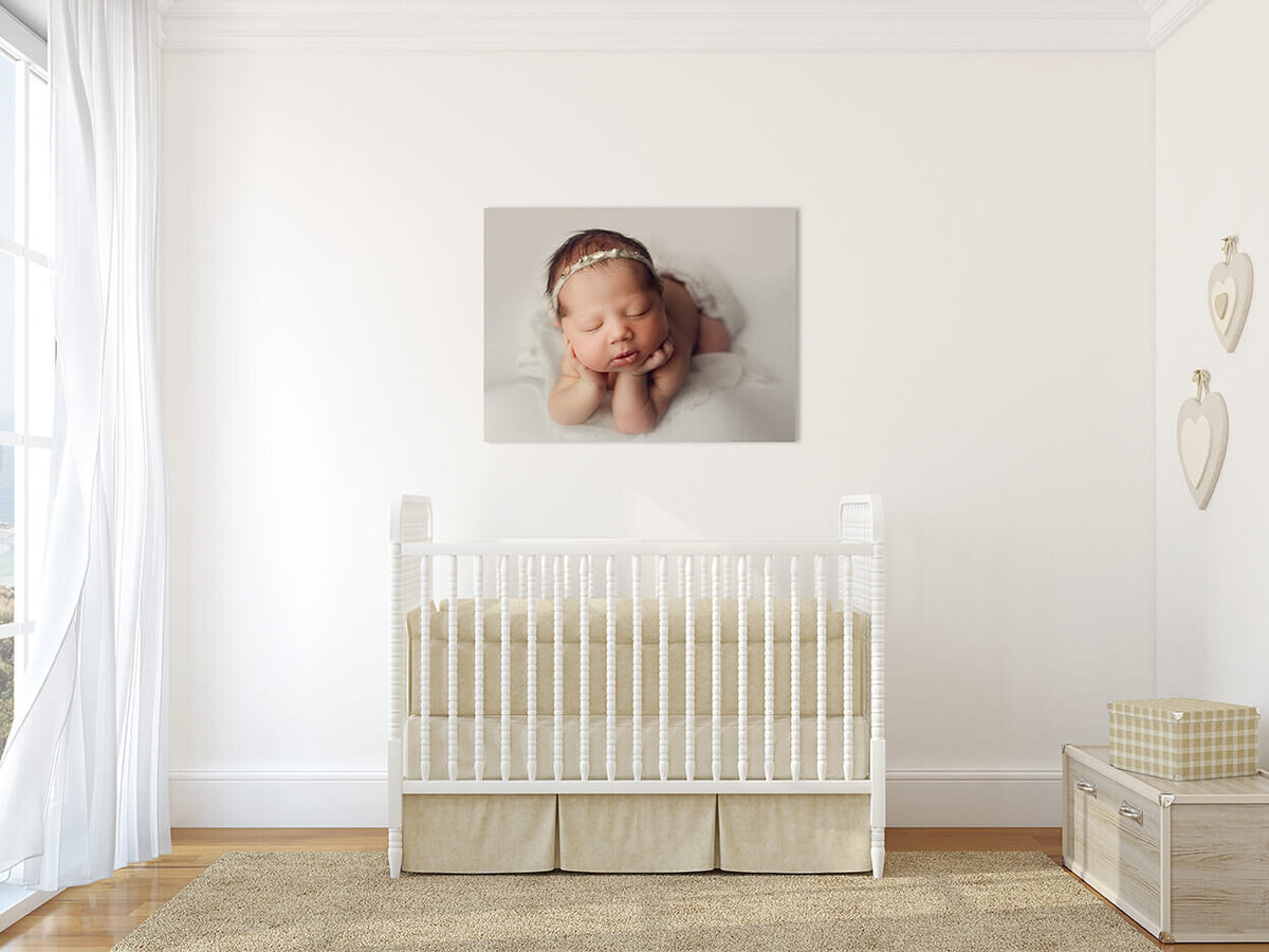 A portrait of a beautiful natural light nursery with a photo of a baby on the wall