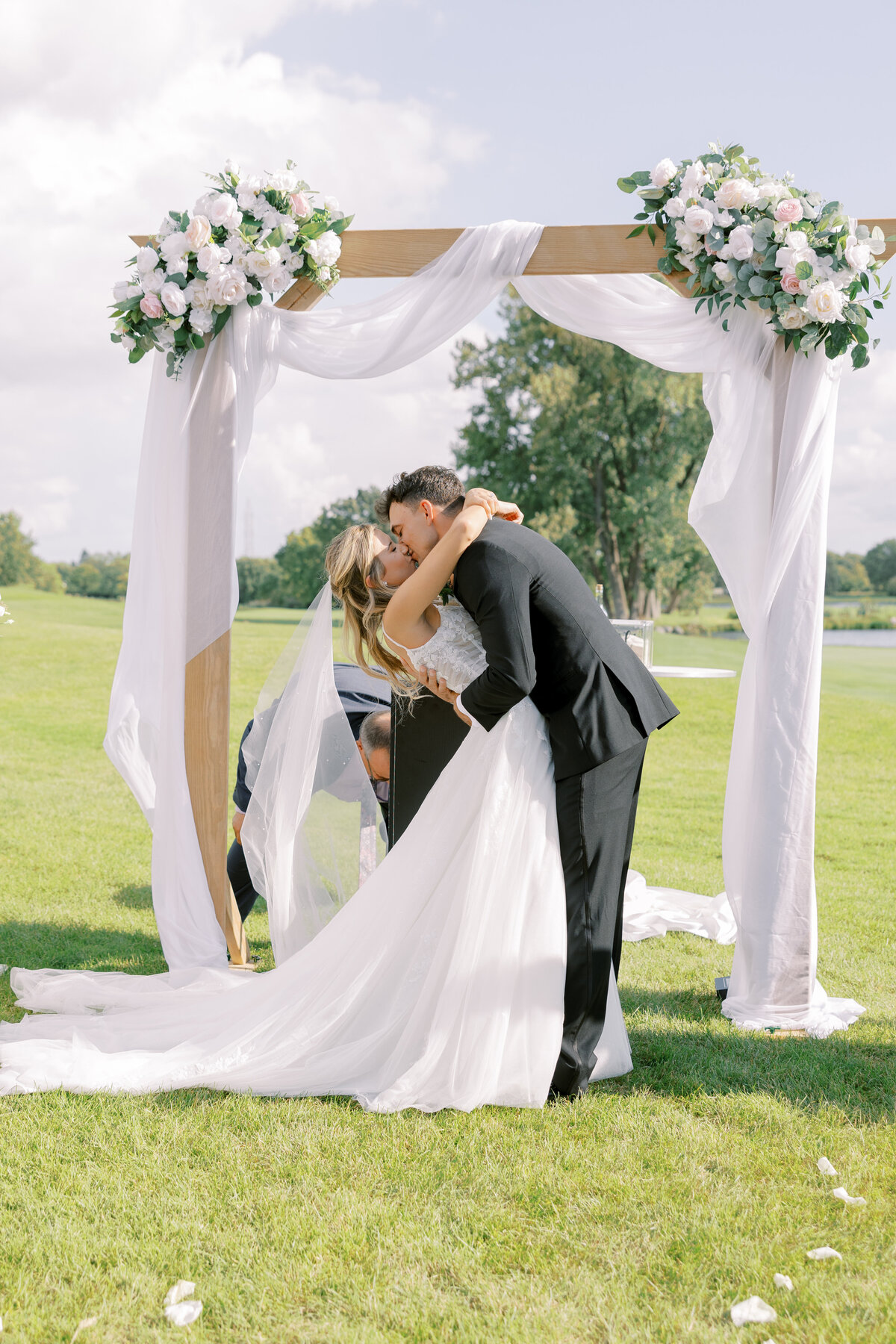 brideandgroomceremonyarchkiss
