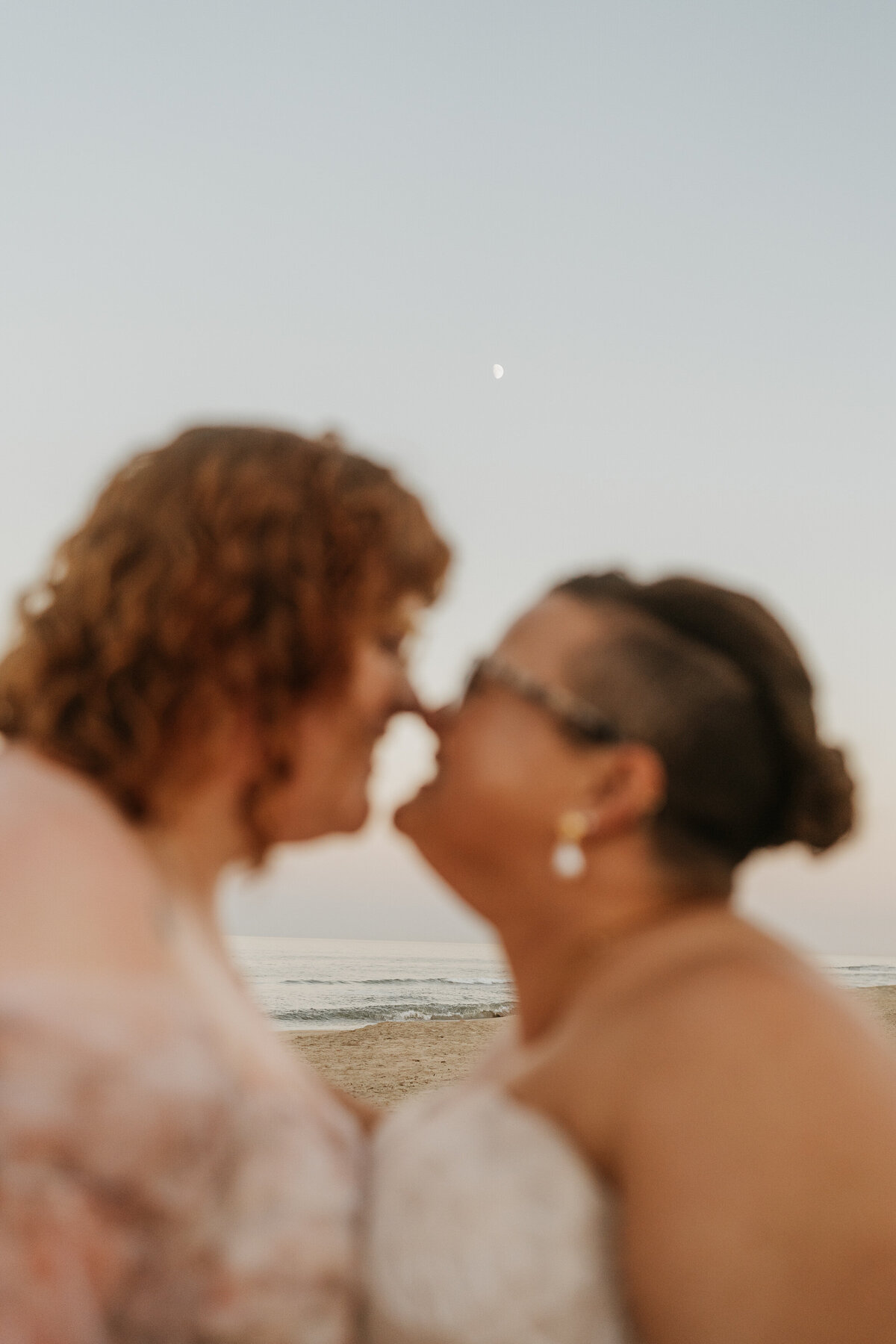 Slightly blurred photo of a newlywed couple with their noses touching 