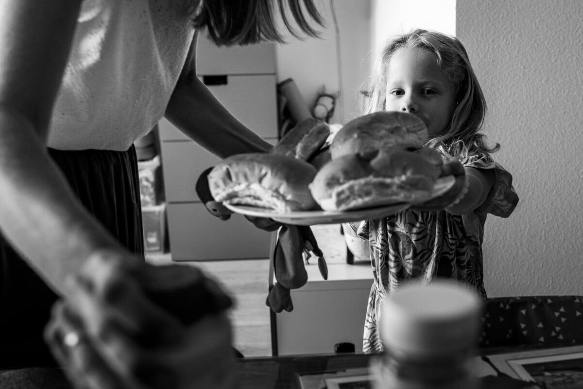 moeder en dochter dekken tafel met broodjes
