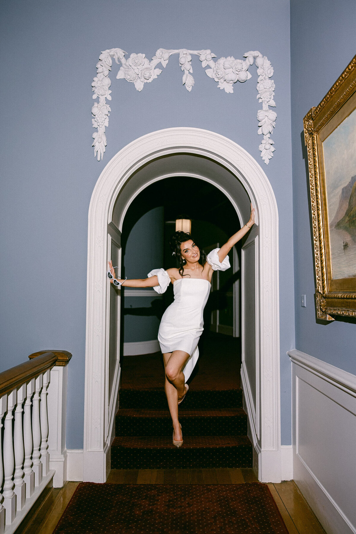 A wedding photo of a bride posing on the staircase at Luttrellstown Castle