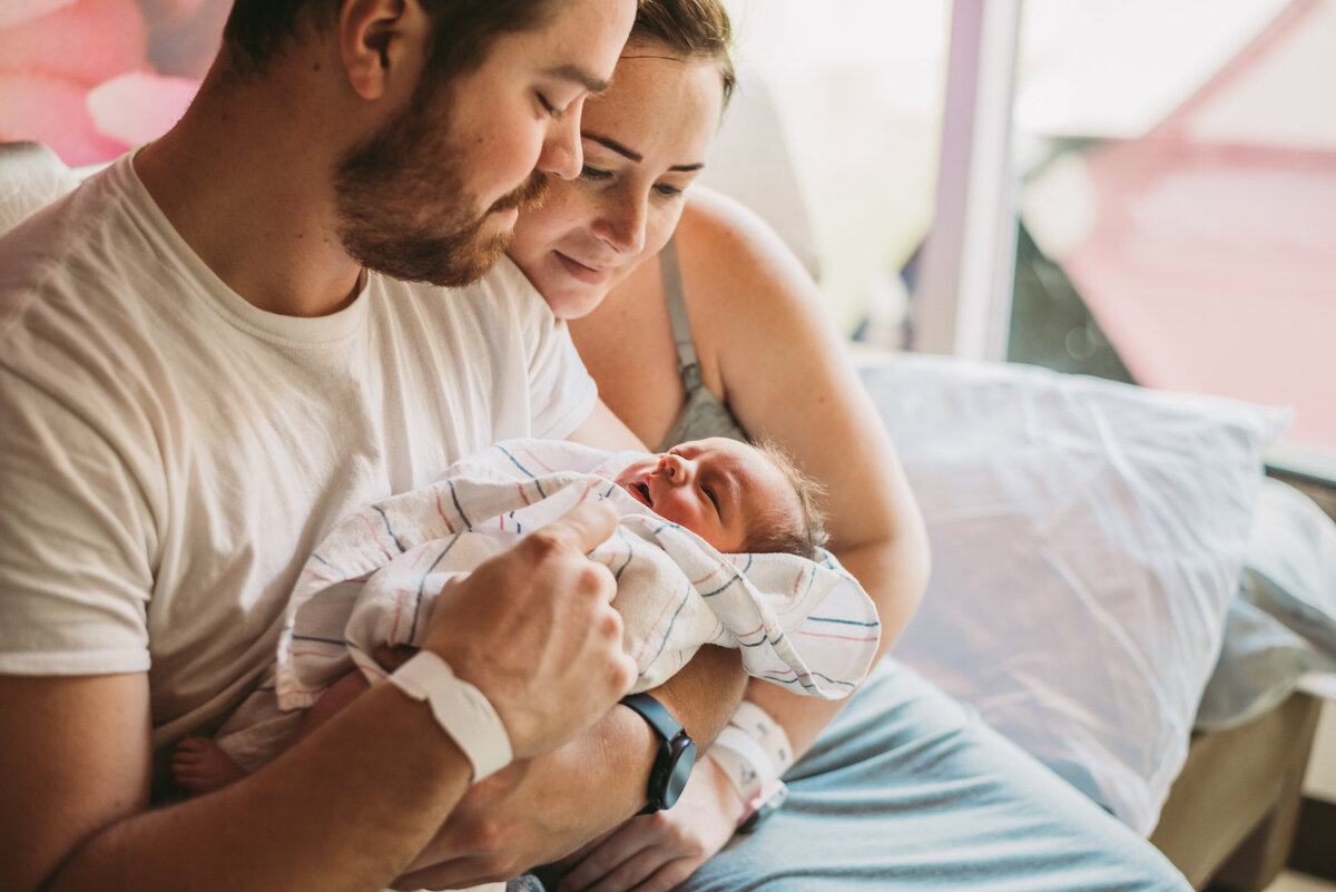 parents holding newborn in hospital