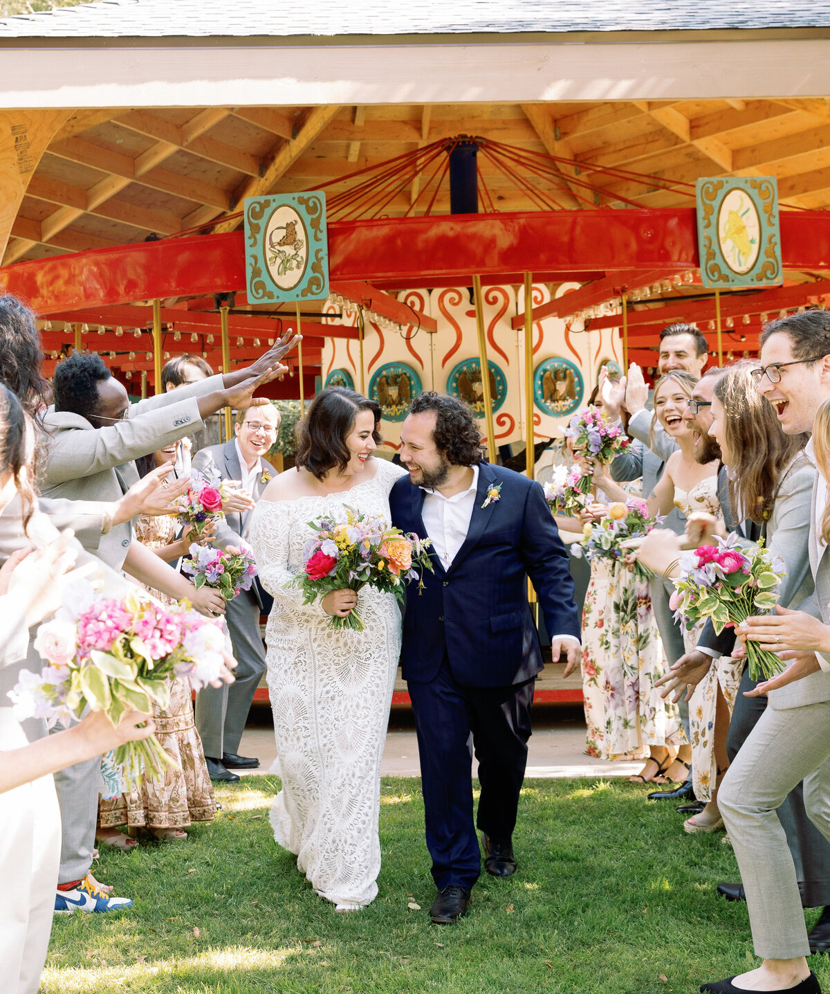 A newlywed couple walking through a tunnel of their guests