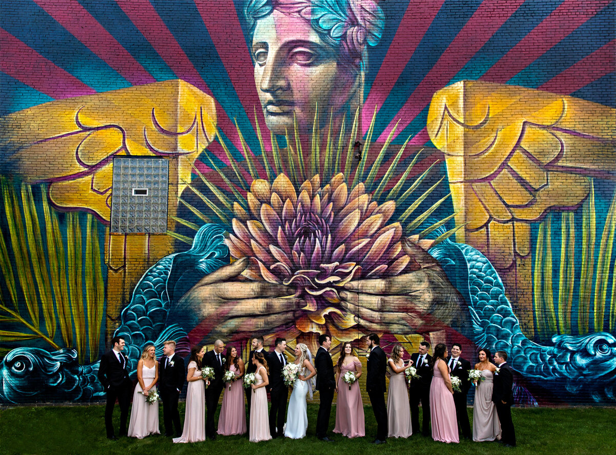 A bridal party talks under a mural of the Guardians bridge in Cleveland.