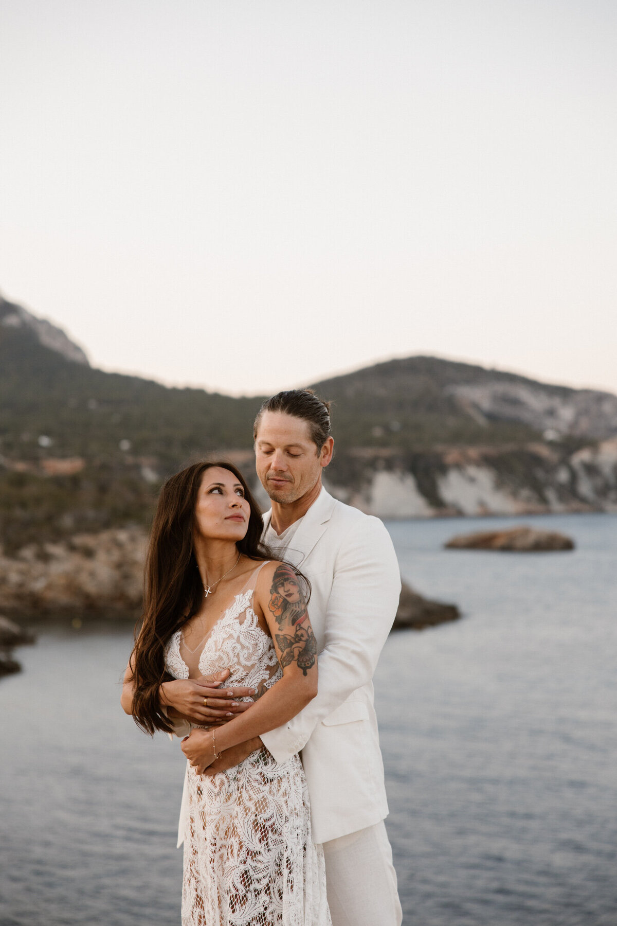 Man standing behind his wife and looking at each other for wedding photography on Ibiza