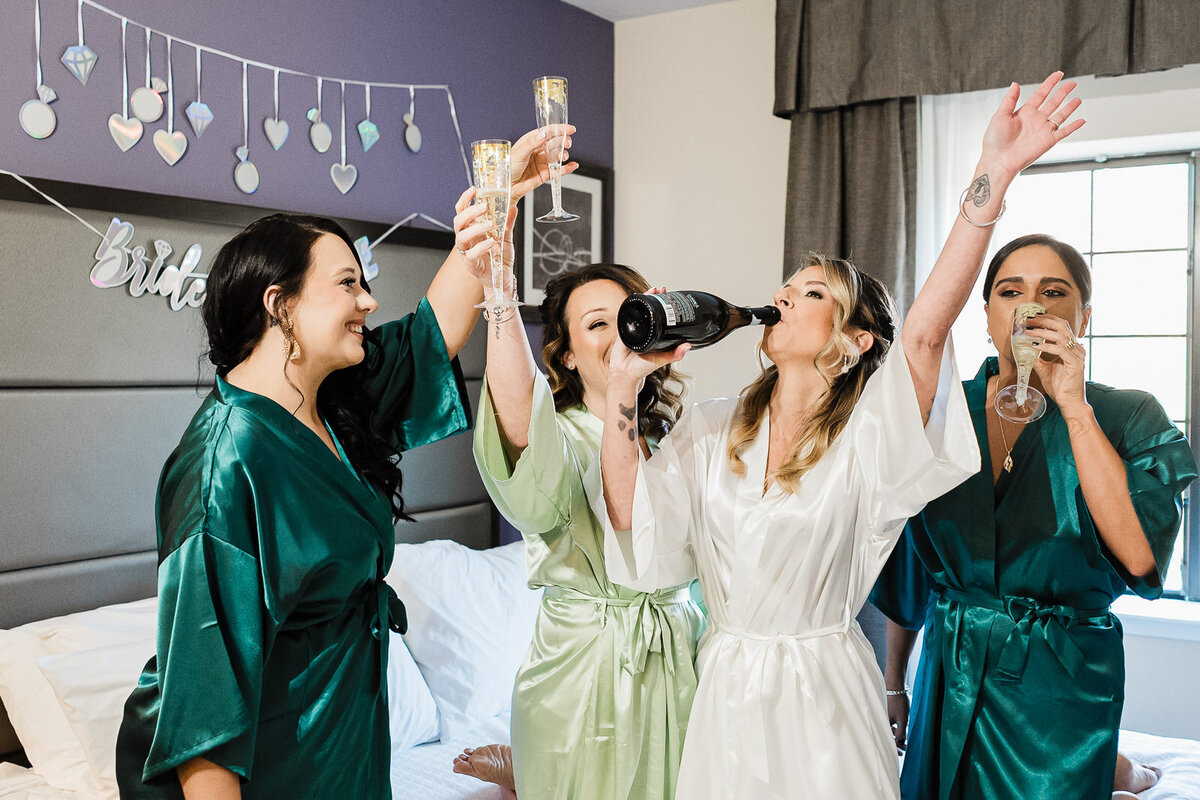 Bride and bridesmaids celebrating with champagne during getting ready, Northern New Jersey wedding photography by Alex Kaplan