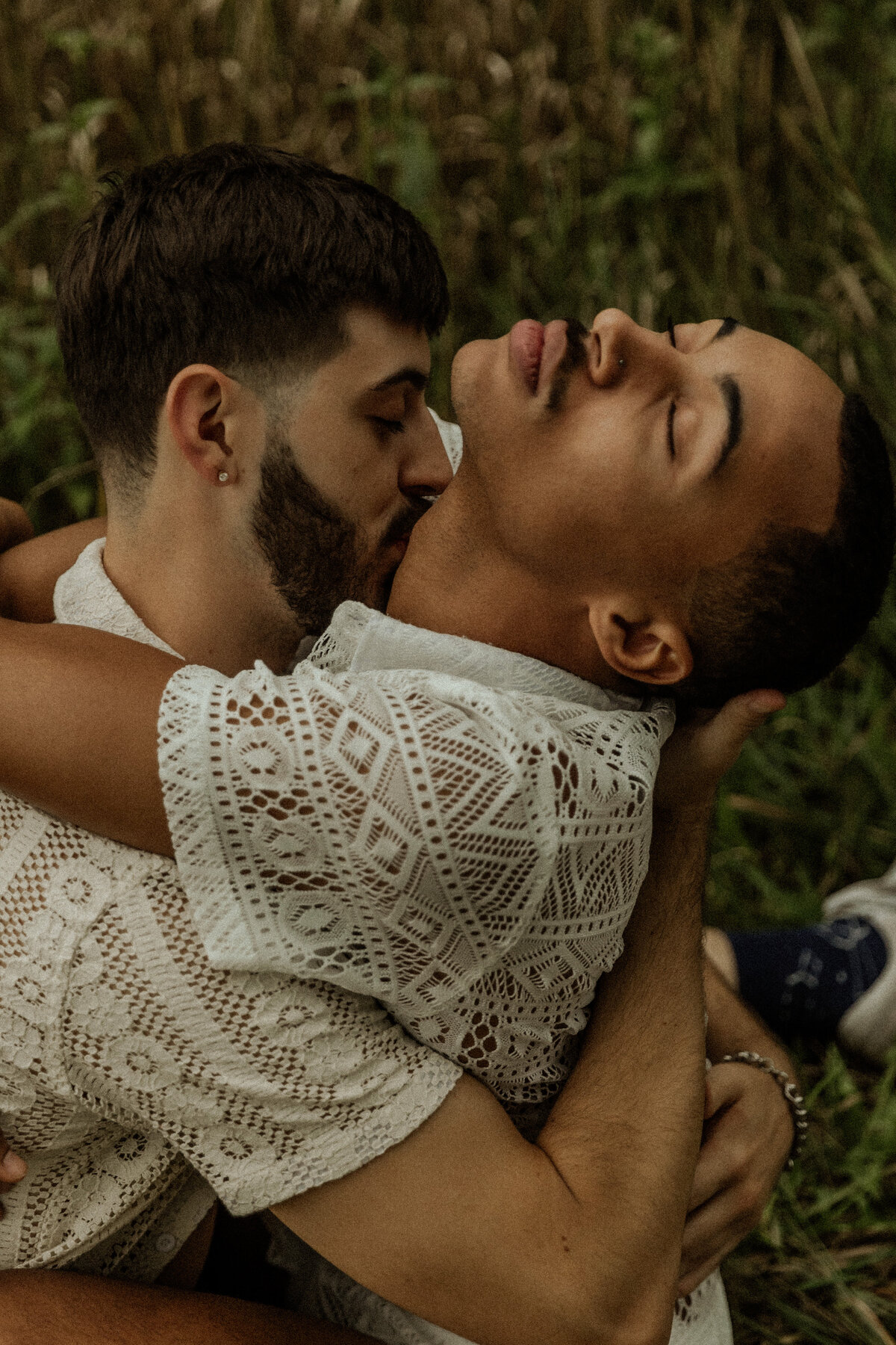 Intimate photo of a Queer couple kissing in the grass  by a MN Couples Photographer 