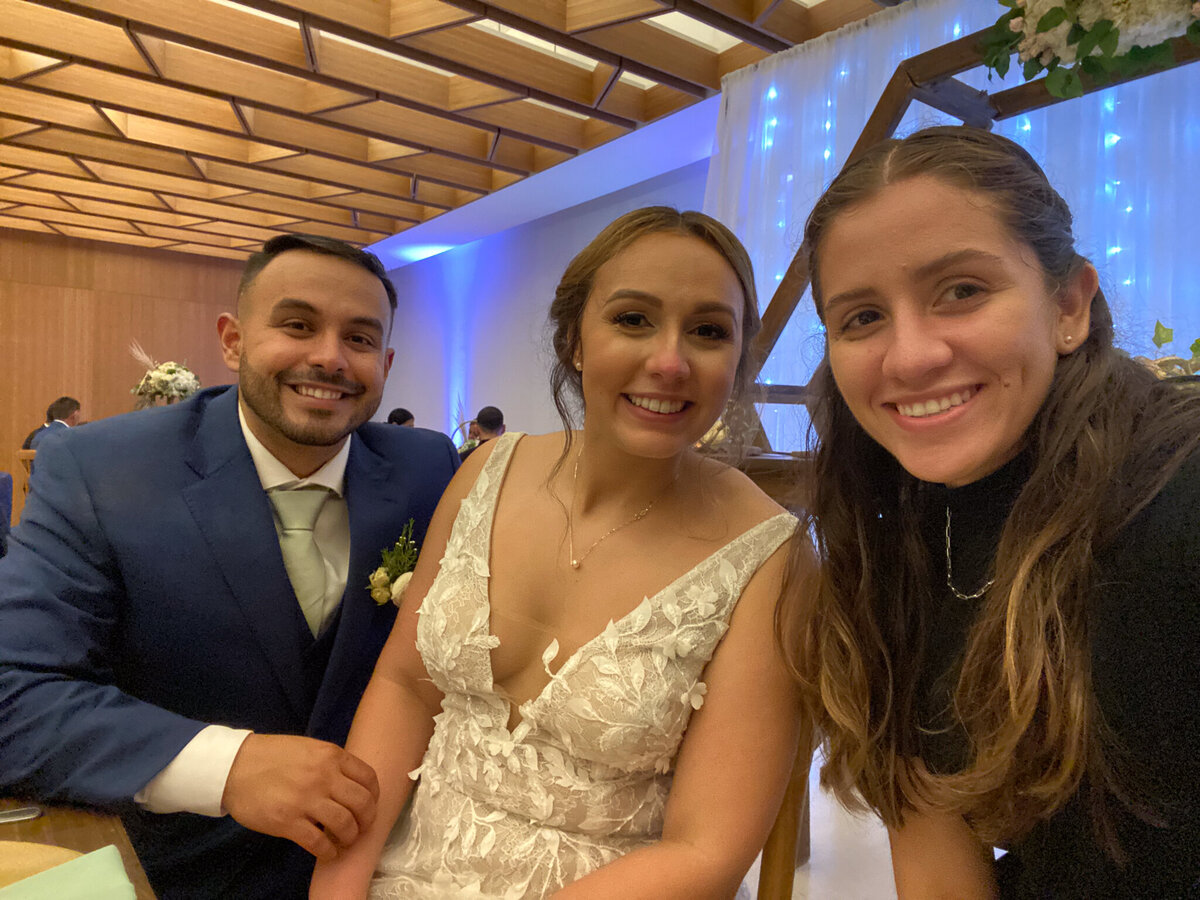 Destination Elopement Photographer sitting with a bride and groom in San Juan, Puerto Rico, smiling at the reception venue.