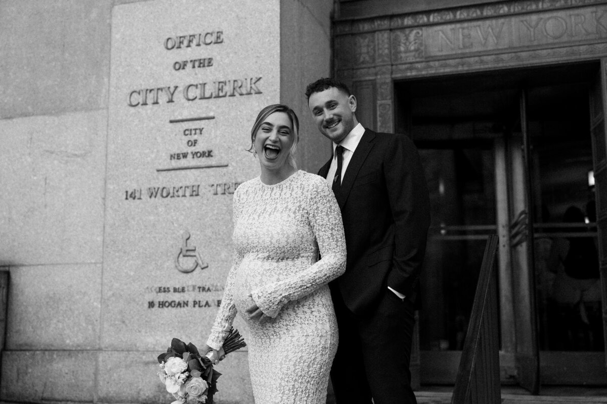 Bride and groom laughing with joy outside their Manhattan city hall ceremony in New York City, NY, by Andrea-Marie Photography