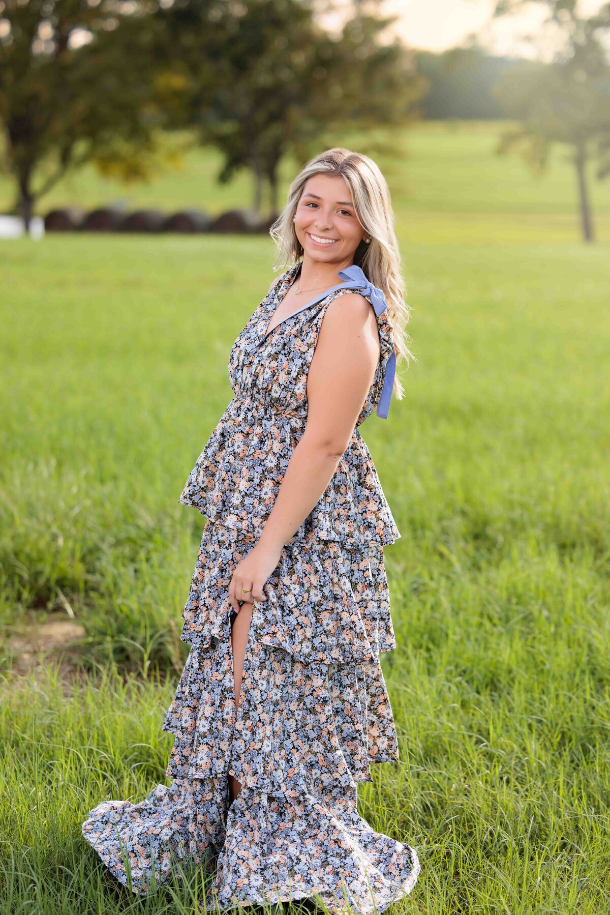 Walking in a field of grass for senior portraits near Raleigh NC.