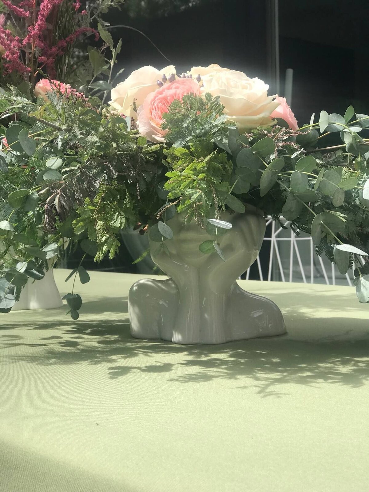 Beautiful pink and green flower centrepiece on a green table cloth