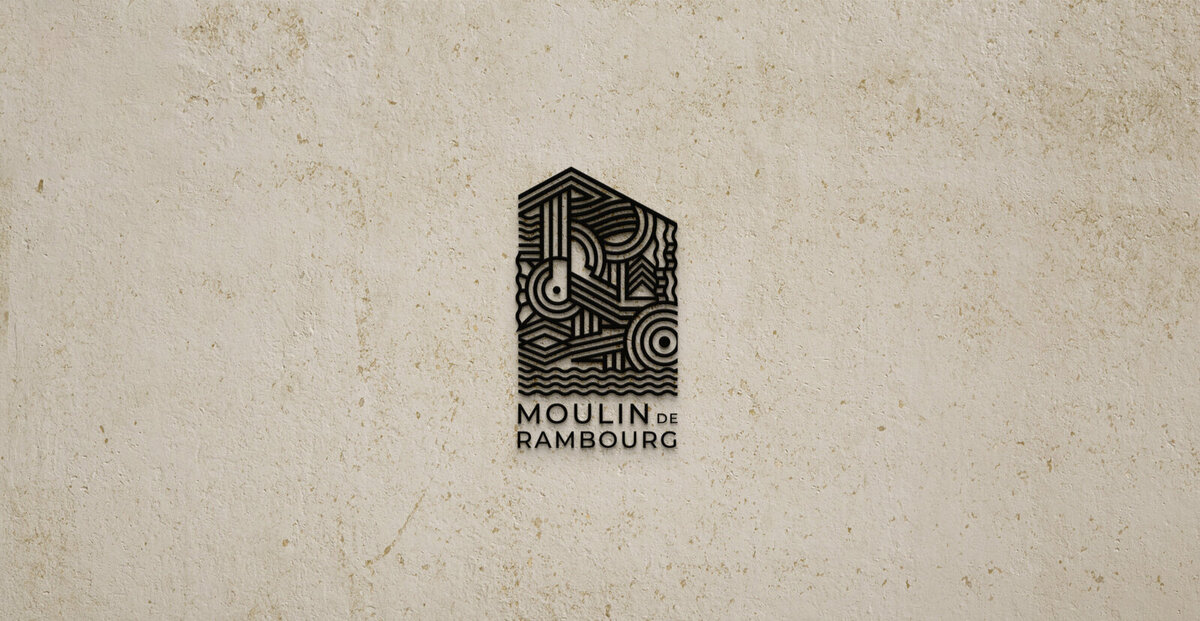 Logo Moulin de Rambourg en impression 3D noir sur un mur de pierre crée par le Studio Youmé, agence de communication à Saint-Gilles-Croix-de-Vie.