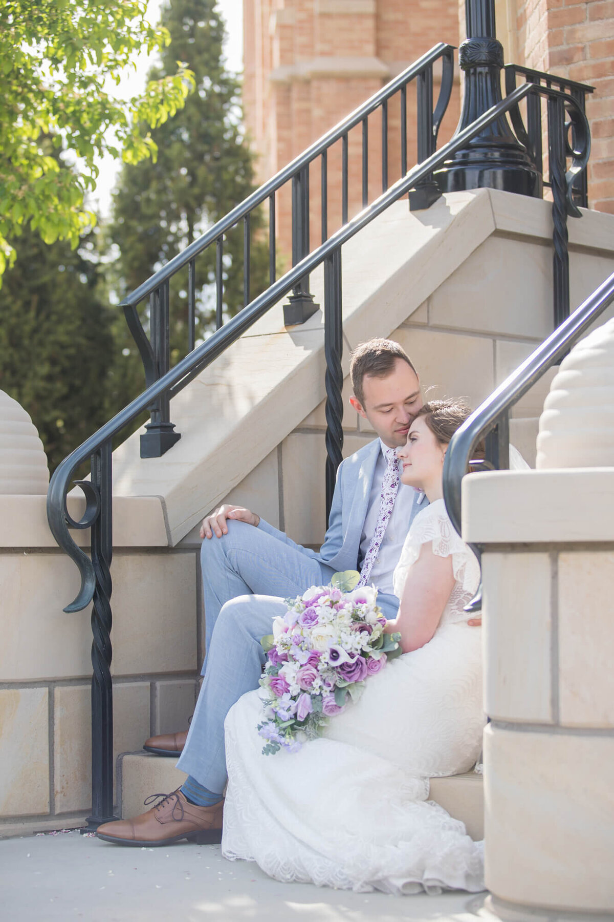 bride and groom sitting on stairs outside