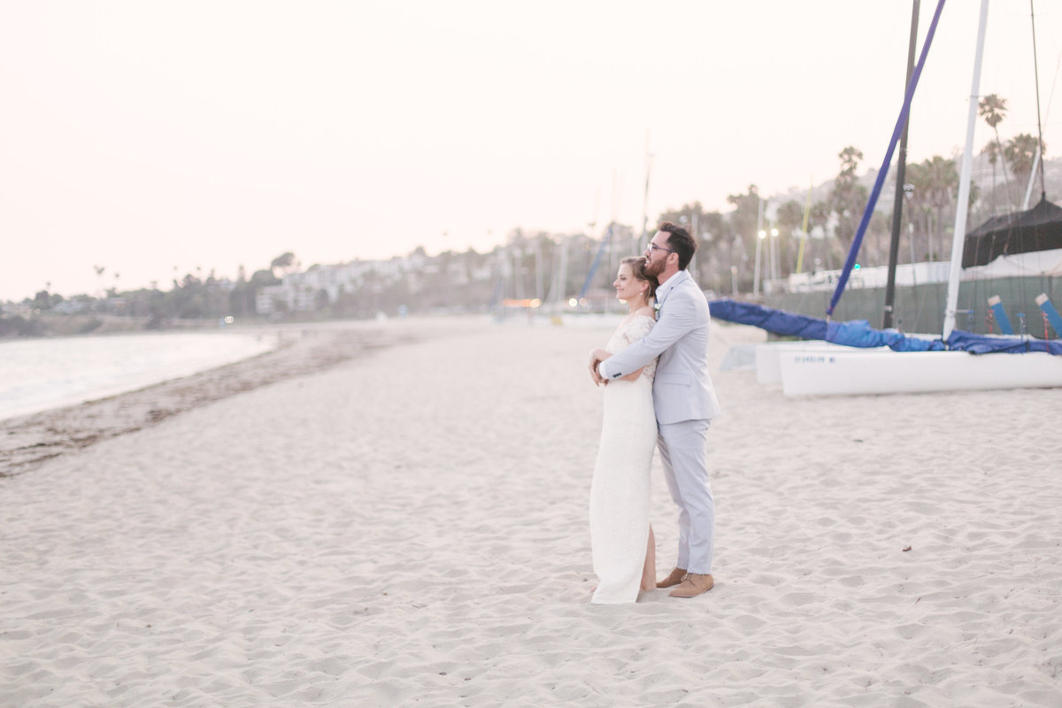 Bride and groom stand along coastline at Santa Barbara Yacht Club wedding