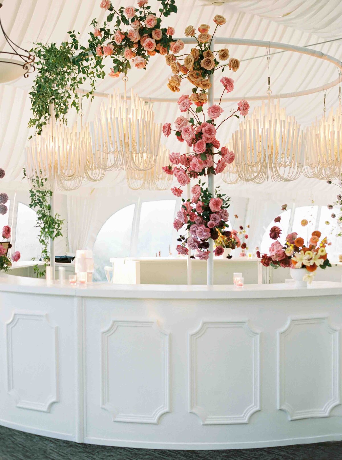 custom white wedding bar with colorful florals in pink and salmon cascading up the side