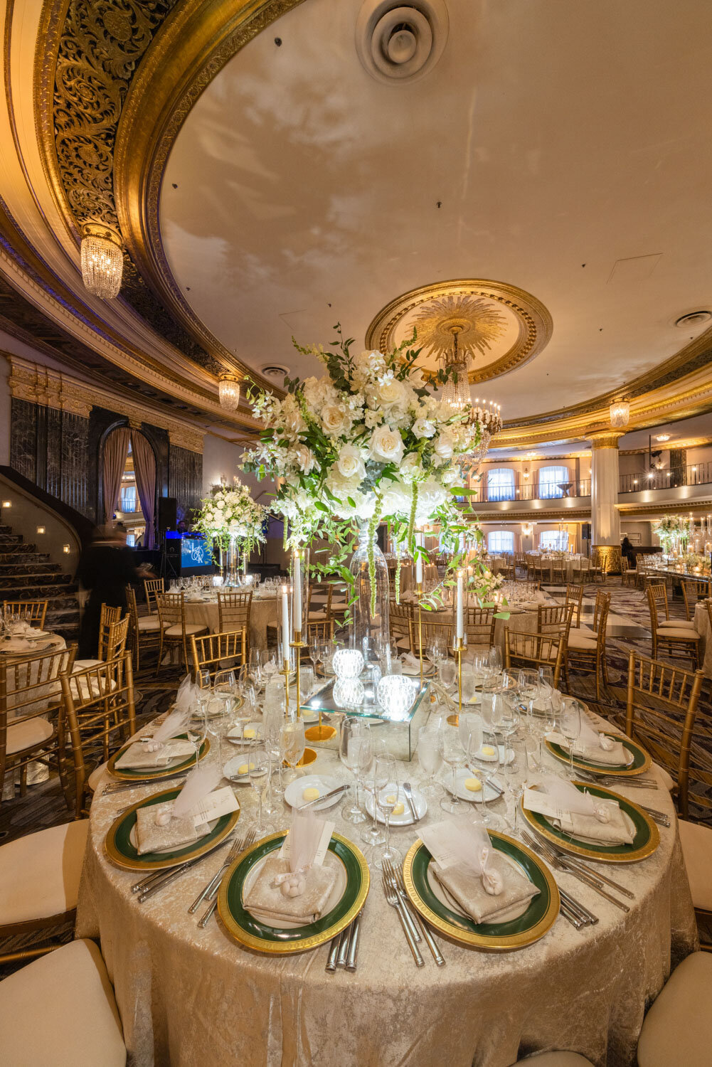 A large room with tables and chairs set for a wedding reception